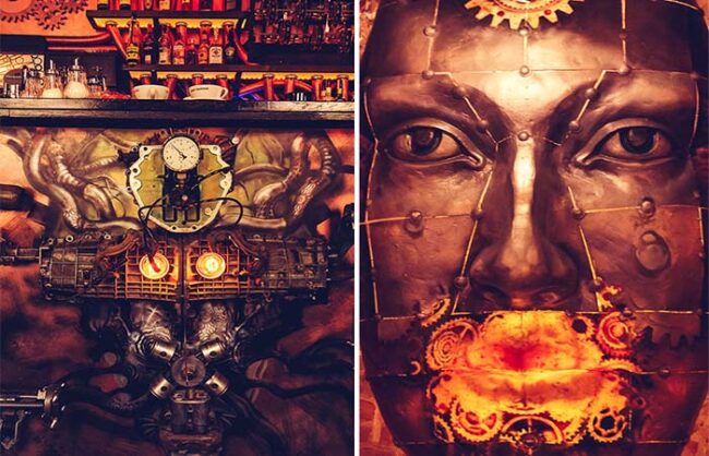 Vue d'ensemble du bar de l'Enigma Café avec comptoir en cuivre, tuyaux apparents et mécanismes cinétiques steampunk