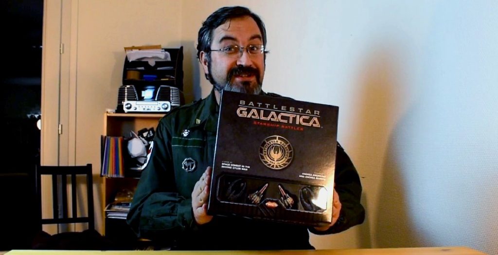 Ca Déboite ! Unboxing de : Battlestar Galactica Starship Battles 1 Merlin tient en main la boite de Battlestar Galactica Starship Battles