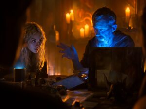 Maître du jeu contrôlant la sonorisation de sa partie sur tablette, joueurs captivés dans une ambiance tamisée avec dés et figurines sur la table